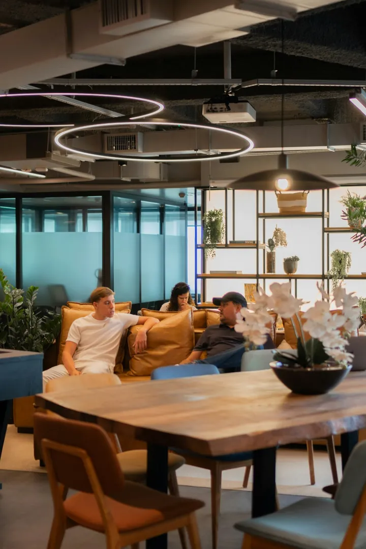 Salariés détendus discutant sur un canapé dans un salon lounge de bureau moderne
